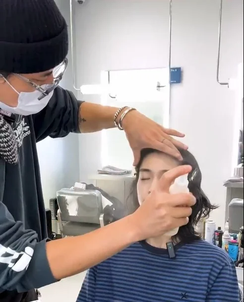 Artista de maquillaje aplicando spray en el rostro