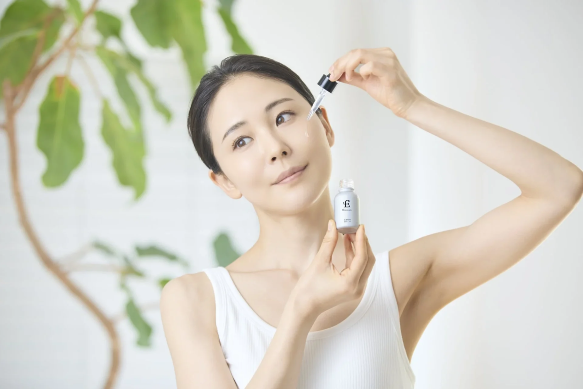 Mujer aplicando s&eacute;rum Eternam SAITAI en su rostro