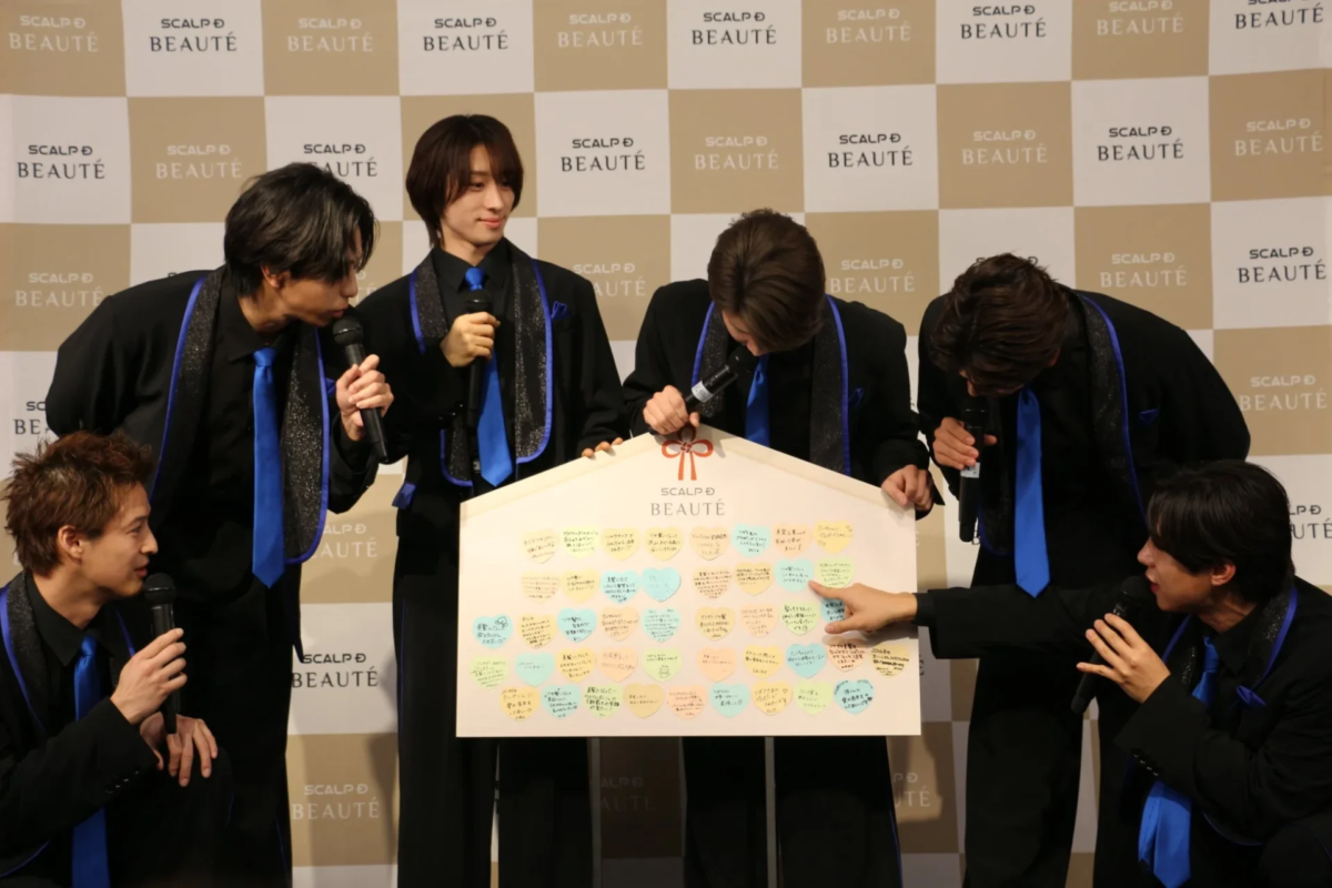 Seis miembros de MATSURI alrededor de un Ema gigante con deseos