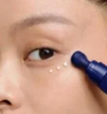 Mujer aplicando s&eacute;rum en el contorno de ojos