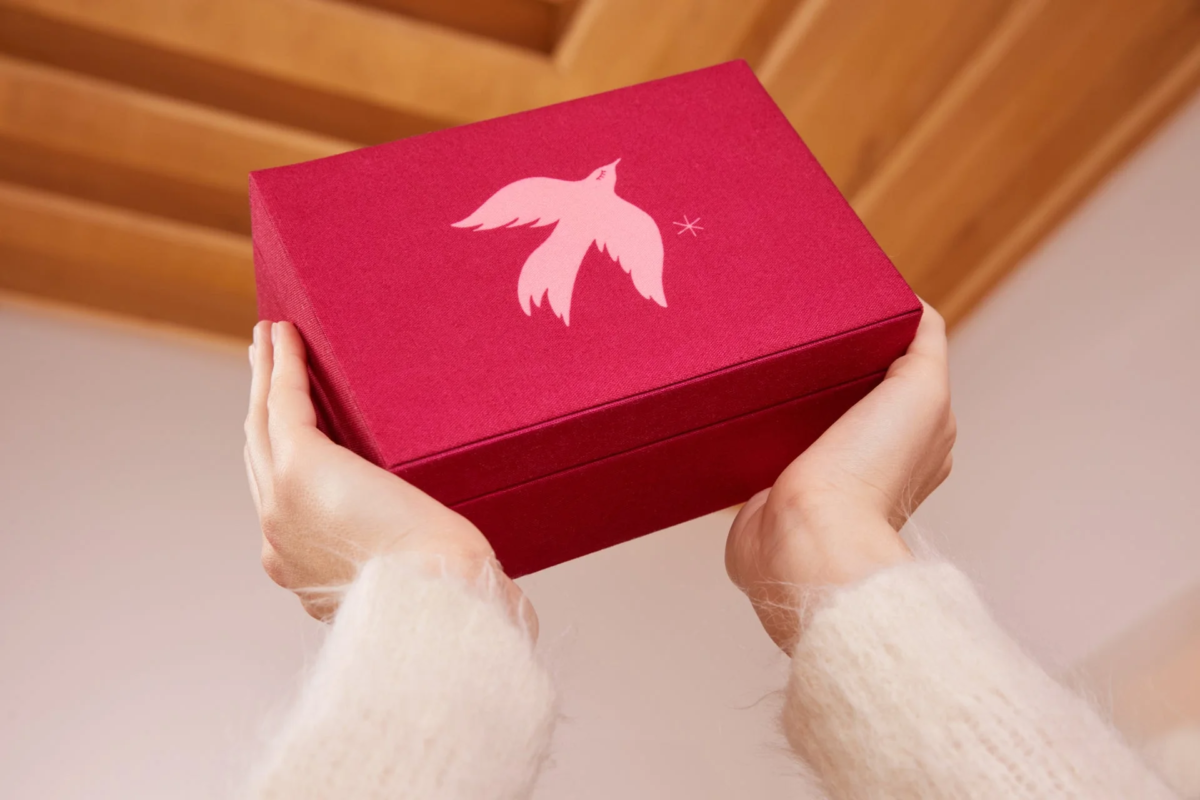 Caja de regalo roja con diseño de pájaro y estrellas