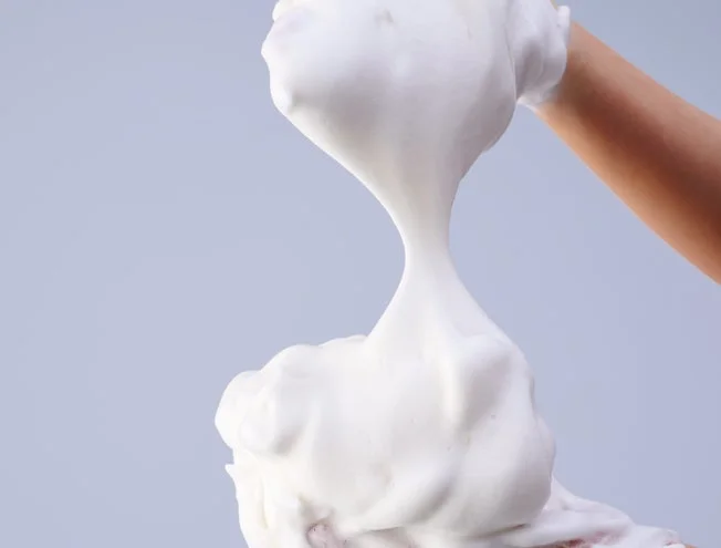 Manos creando una espuma densa y cremosa