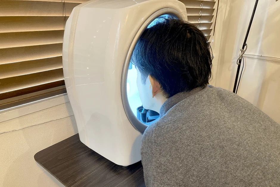 Hombre utilizando un dispositivo de diagn&oacute;stico facial