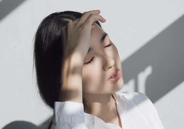 Mujer con los ojos cerrados bajo el sol