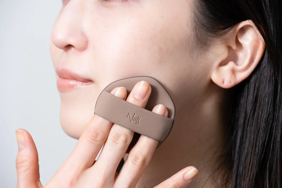 女性がパフを使用している画像