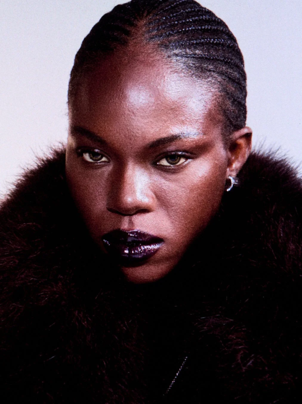 Maquillaje de Gucci Beauty con labios oscuros y trenzas