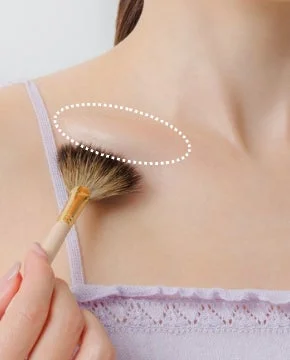 Mujer aplicando maquillaje en el escote