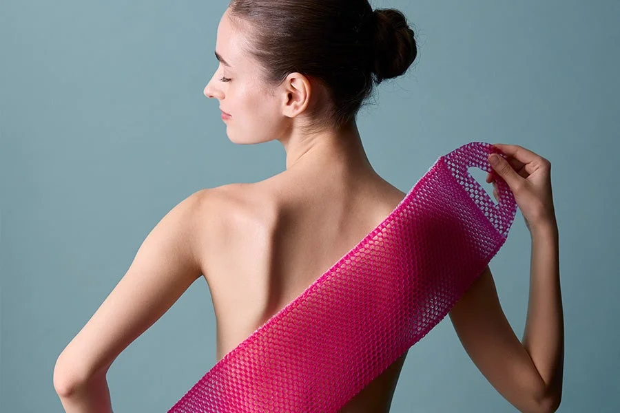 Mujer mostrando un cepillo de ducha STIMULITE HONEYCOMB