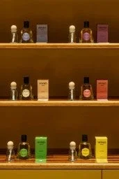 Estantes de madera con botellas de perfume y productos de belleza