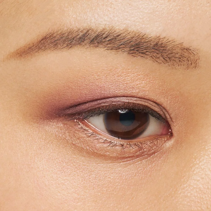 Primer plano de un ojo con maquillaje en tonos rosas