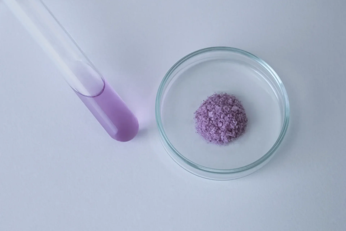 Frasco con l&iacute;quido morado y polvo en un plato