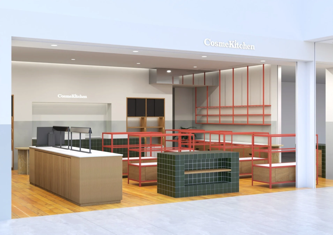 Interior de la tienda Cosme Kitchen con mostradores de madera y estantes rojos