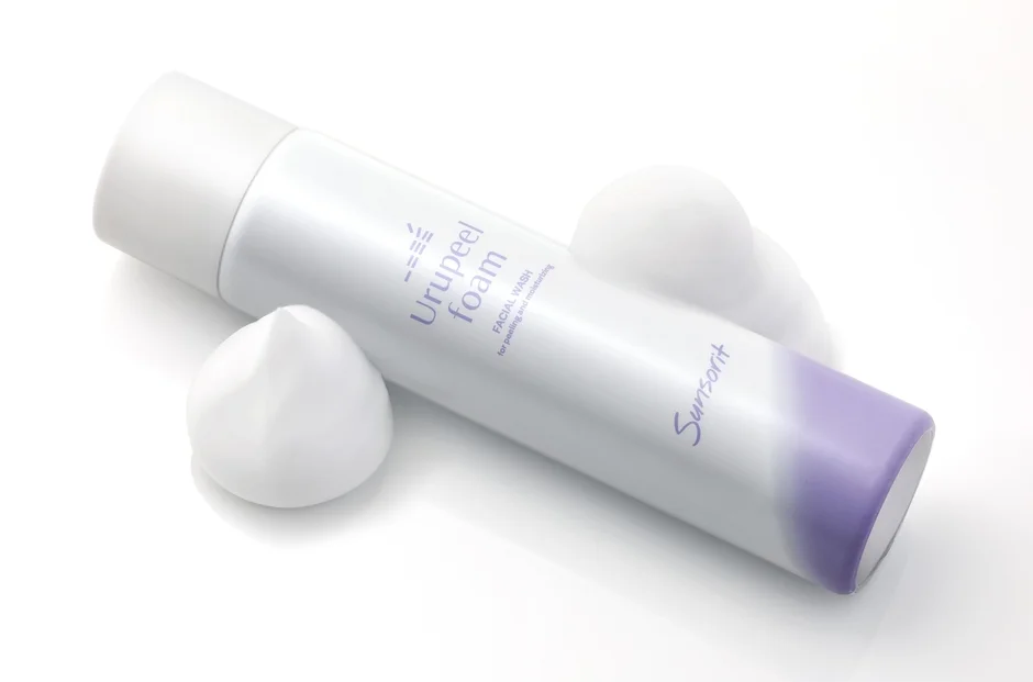 Botella de Urupeel Foam FACIAL WASH de Sunsorit, con espuma blanca alrededor, sobre un fondo blanco.
