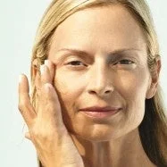 Mujer aplic&aacute;ndose crema en la cara