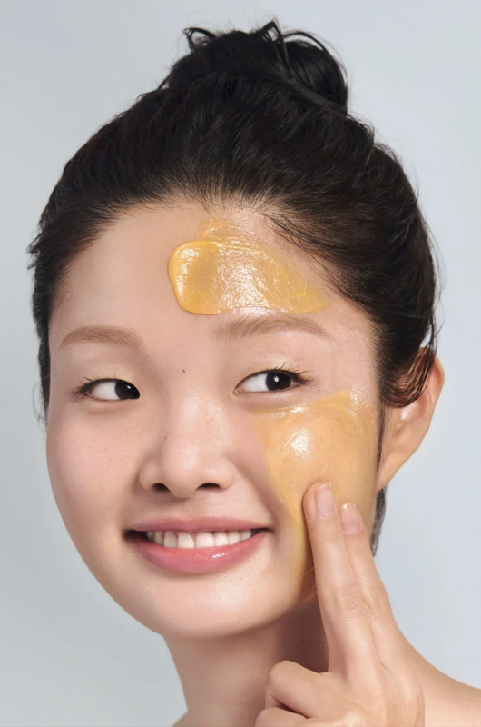 Mujer aplicando mascarilla facial