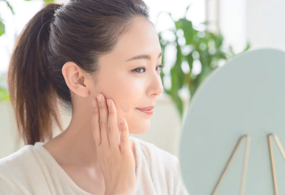 Mujer aplicándose maquillaje en el rostro