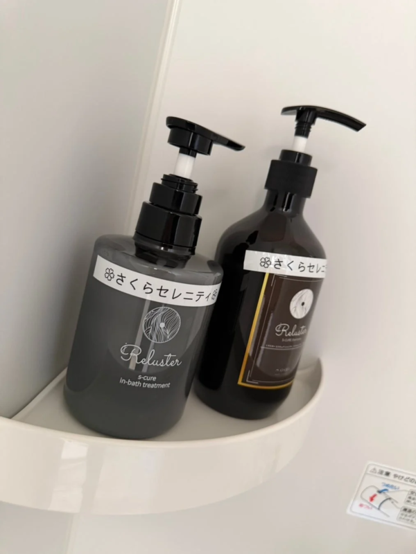 Productos de cuidado capilar Reluster Sakura Serenity en un estante blanco de ba&ntilde;o