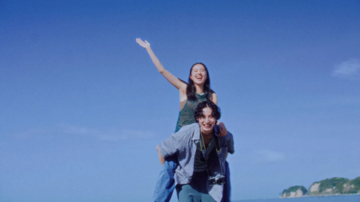 Pareja sonriendo bajo el cielo azul