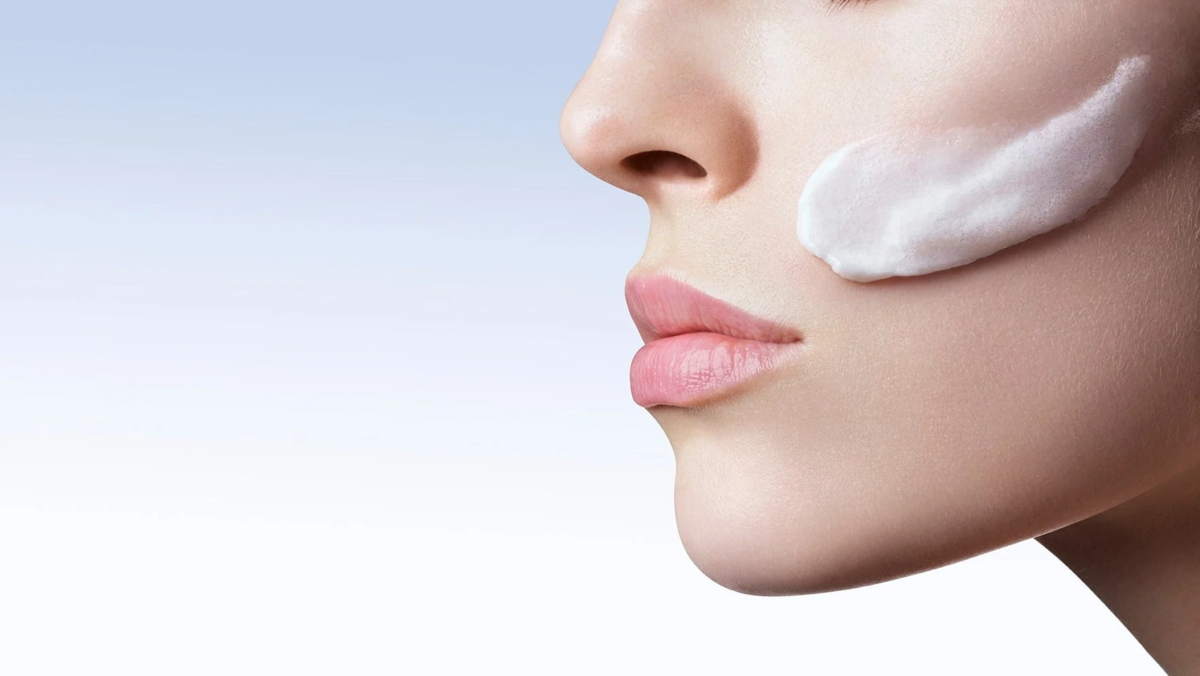 Mujer con crema en la mejilla