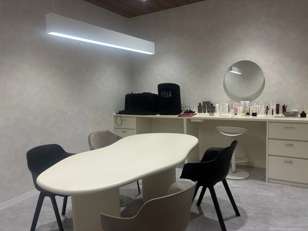 Moderna sala de asesoramiento con mesa blanca y productos de belleza