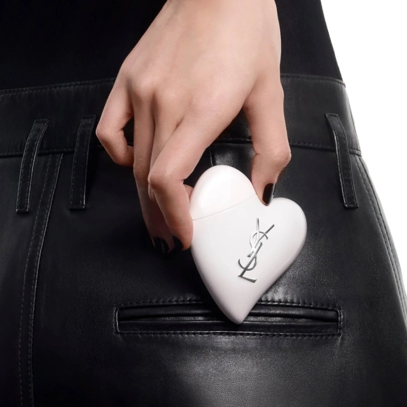 Mano sacando el corazón YSL de un bolsillo