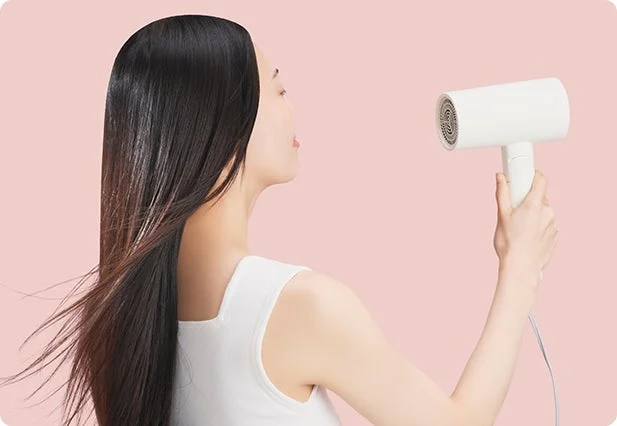Mujer secándose el pelo
